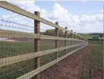 Agricultural square post & rail fence complete with barbed wire and netting.